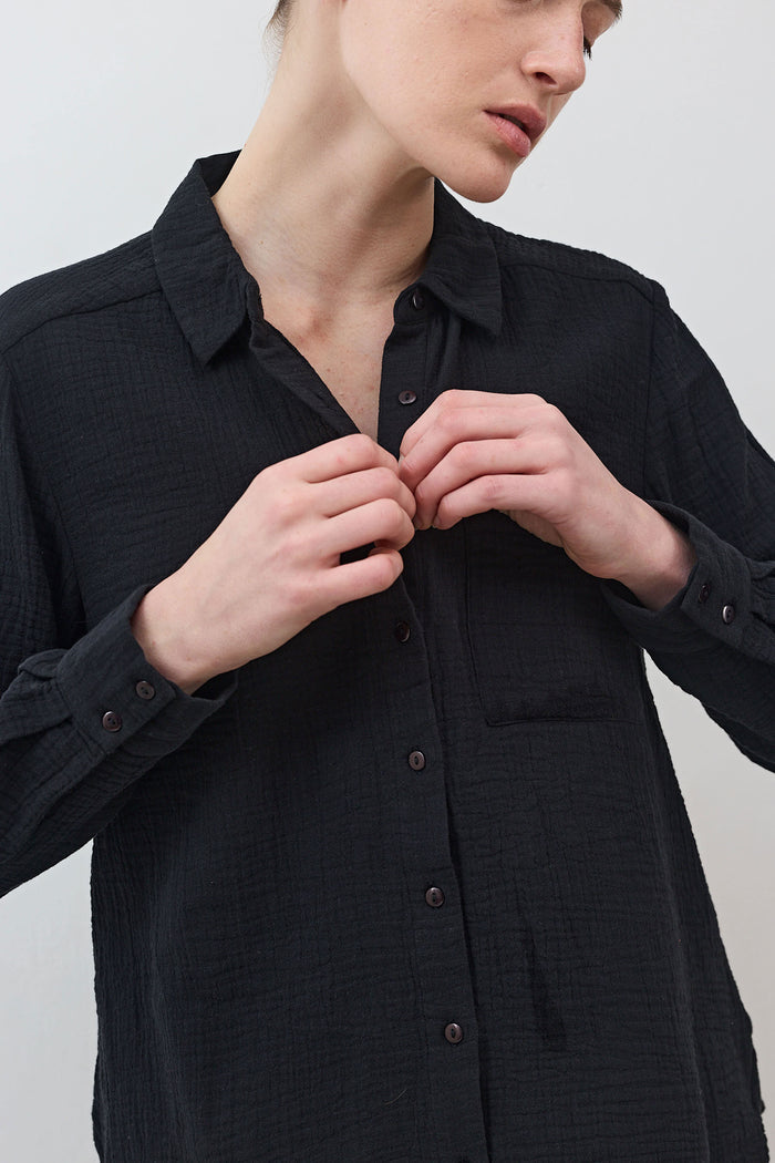 Black button-down tunic with pointed collar and front buttons, long sleeves