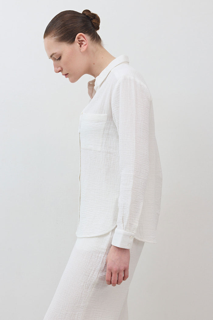 Airy button-down tunic in off-white with long sleeves and curved side hem