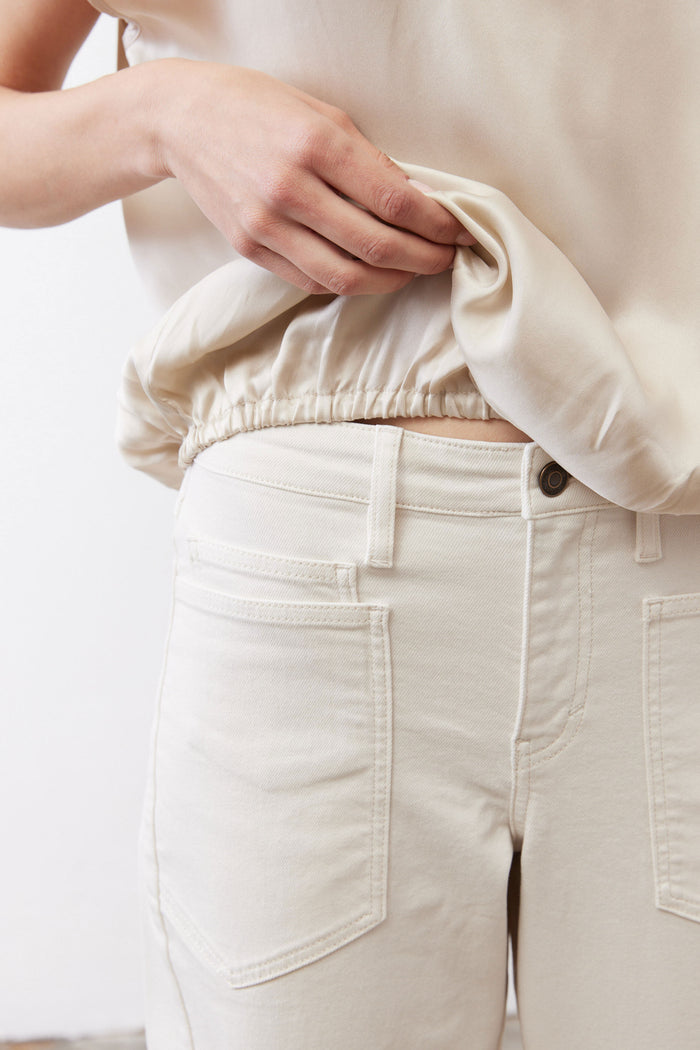 Light cream silk blouse hem with elastic gathering at the bottom