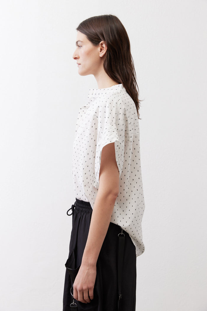White blouse with black dot print, side view with short dolman sleeves and button front