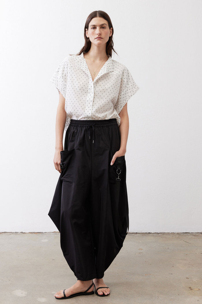 White dot-print blouse with short sleeves and V-neck button front