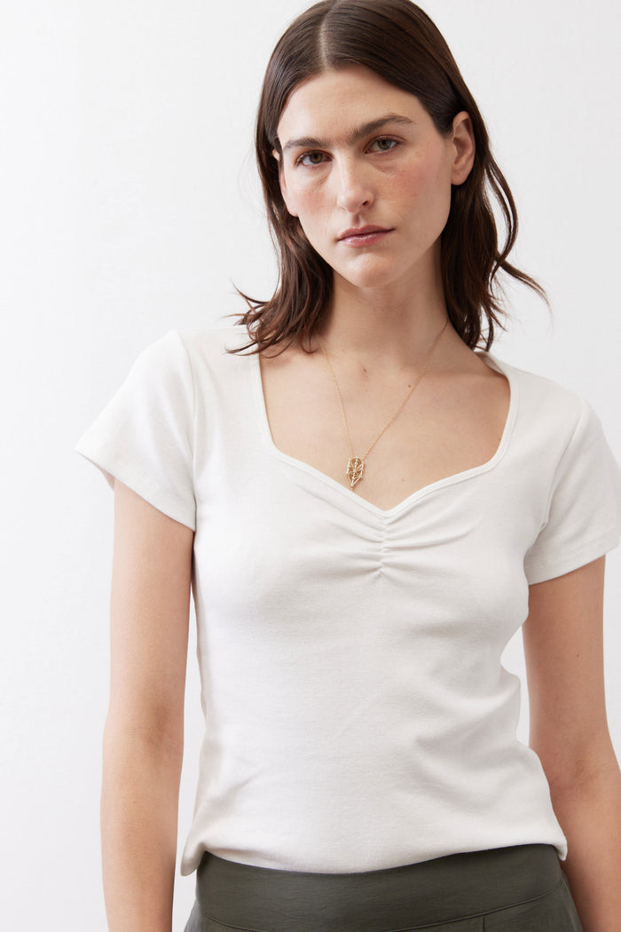 Ivory short-sleeve top with V-dipped neckline and gathered center seam