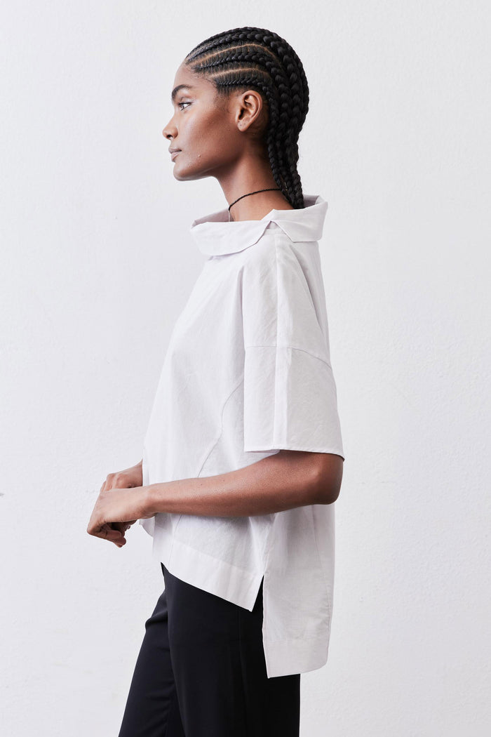 White dolman drape-neck top, close side view with draped neckline