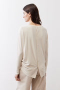 Cream long-sleeve crewneck top, back view with center buttons