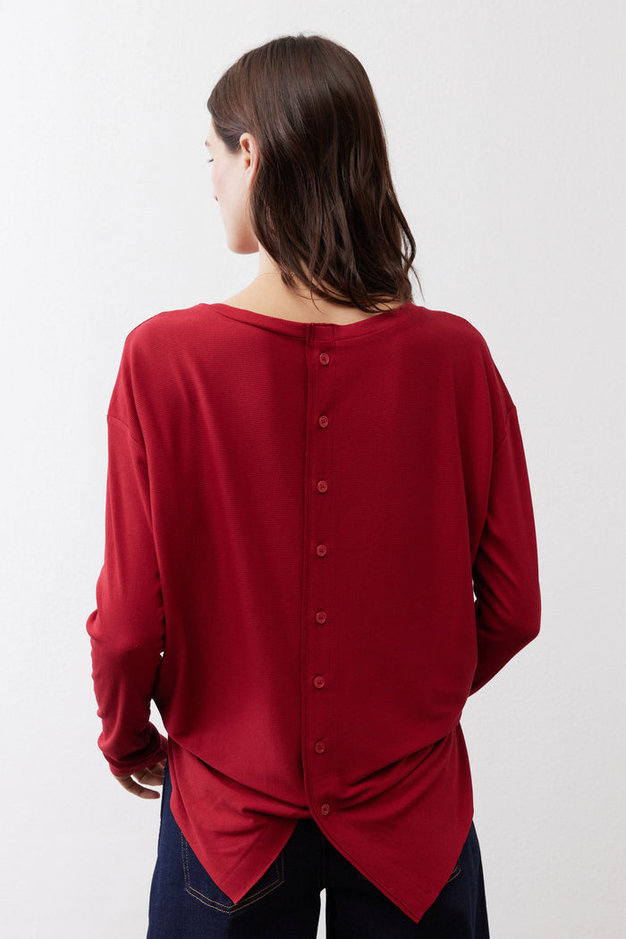 Garnet red long-sleeve top, back view with button placket and knot hem