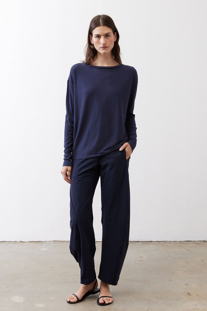 Deep navy long-sleeve top with round neckline and draped waist detail