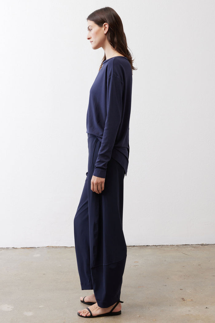 Deep navy long-sleeve top side view with tied back and relaxed drape