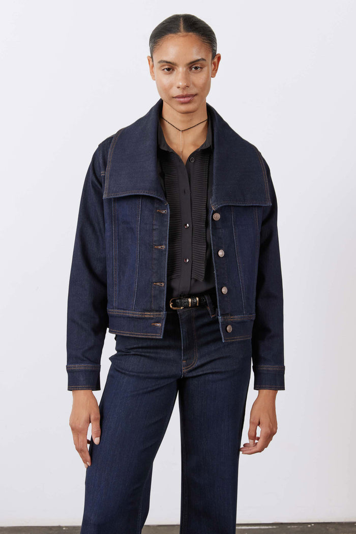 Dark denim jacket with button-front, pointed collar, and chest button flap pockets