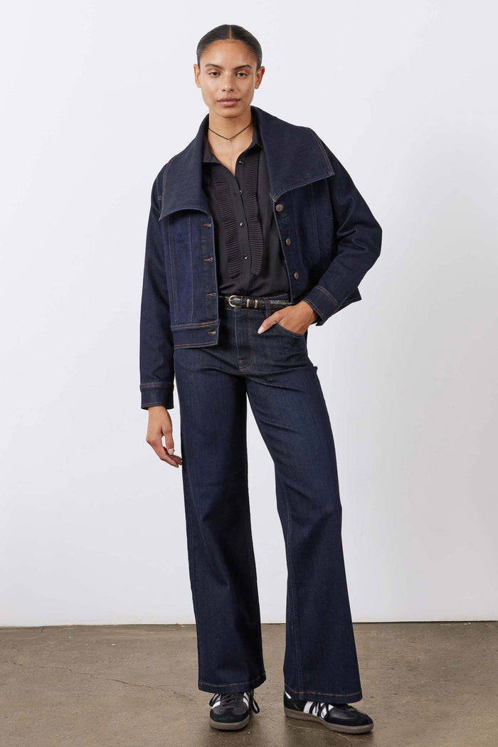 Dark denim jacket with pointed collar and chest button pockets, long sleeves