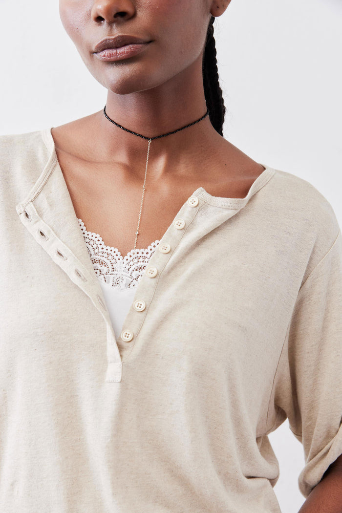 Oat half-button top close-up: lace-trim neckline and front button placket