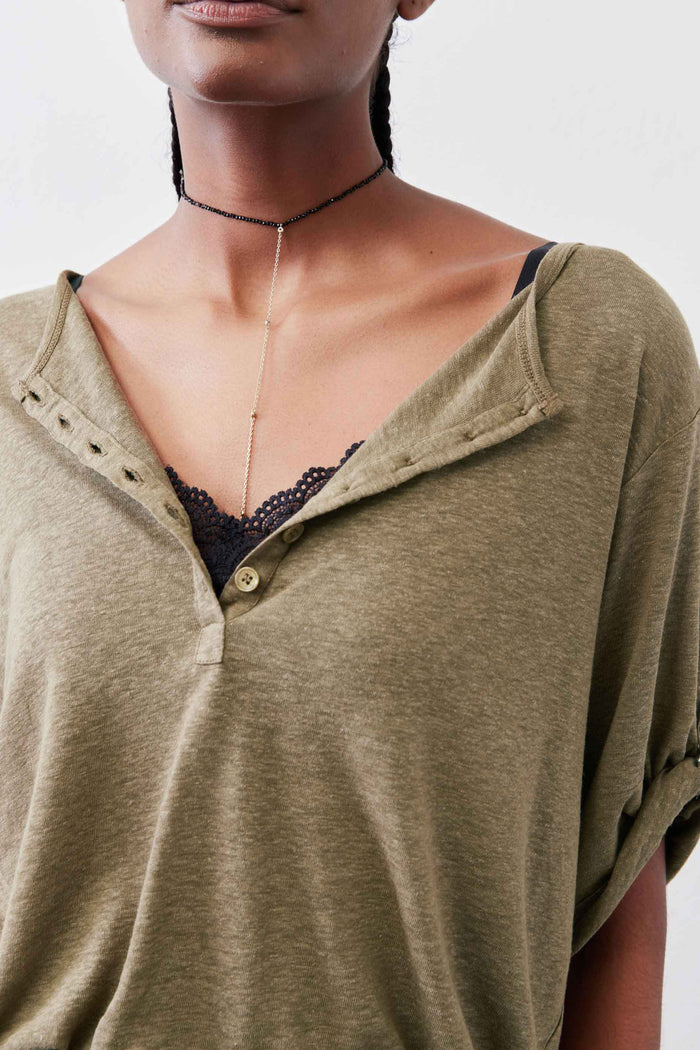 Warm olive neckline detail of half-button henley with V-neck opening