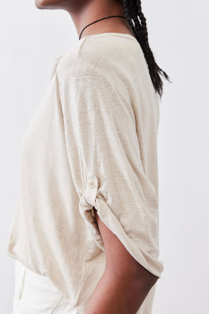Oat top side view with elbow sleeves and buttoned cuff