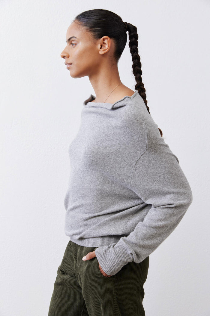 Silver heather knit sweater, long sleeves, side back view with ribbed cuffs.