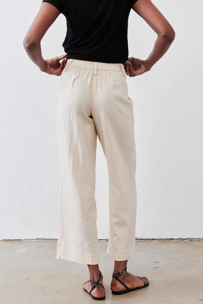 Oat linen A-line pants with elastic waistband and relaxed wide-leg silhouette.