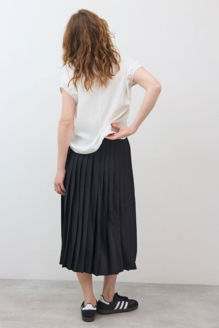 Black pleated pull-on skirt with gathered elastic waistband, mid-calf length