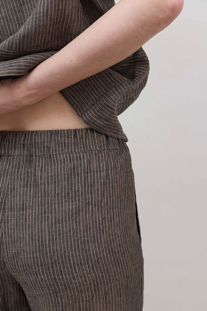 Charcoal striped linen pants fabric close-up at waist and side seam
