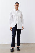 White asymmetric button-down shirt with pointed collar, long sleeves, front split