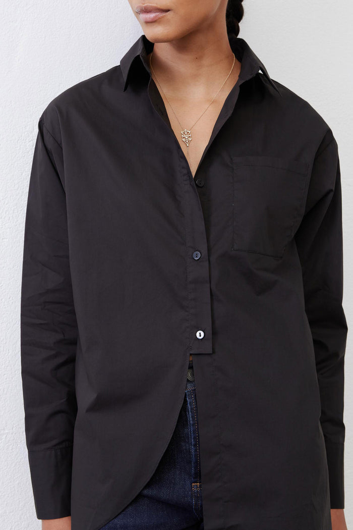 Black asymmetric button-down shirt close-up with collar and chest pocket