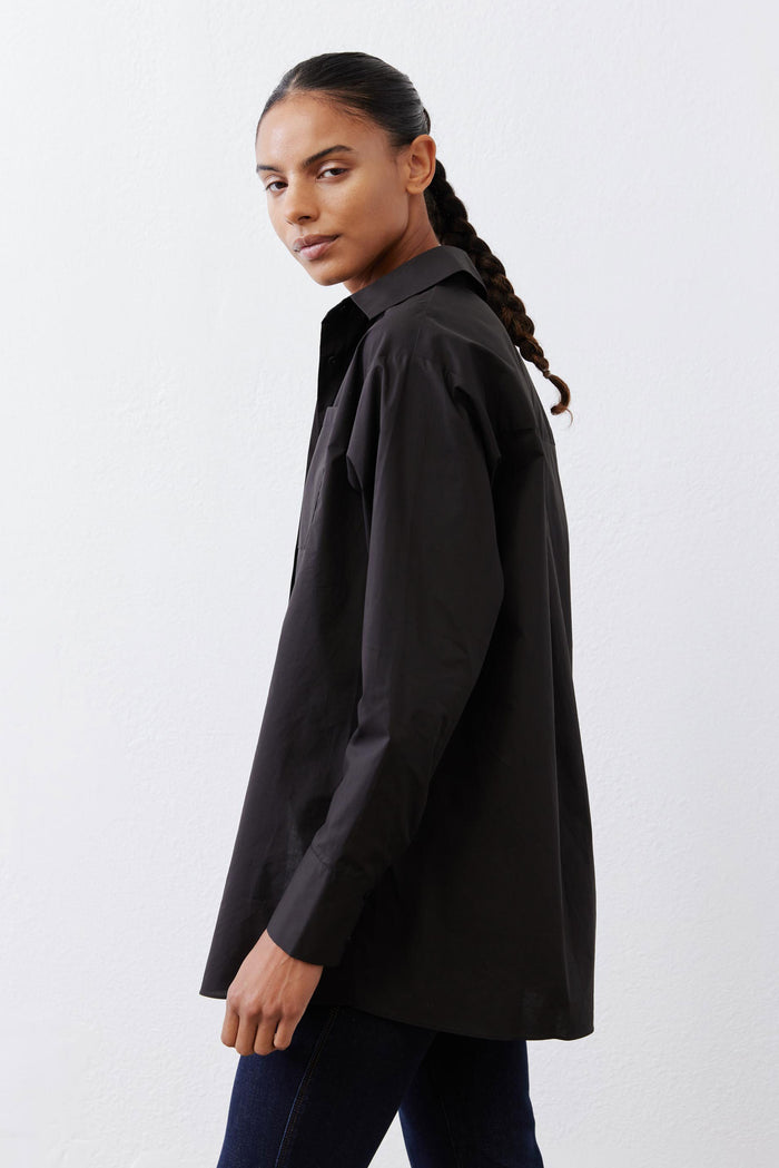 Black asymmetric button-down shirt side profile with relaxed straight sleeves
