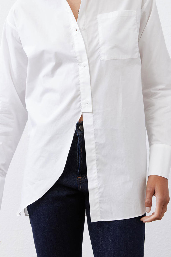 White asymmetric button-down shirt close-up with front split and chest pocket