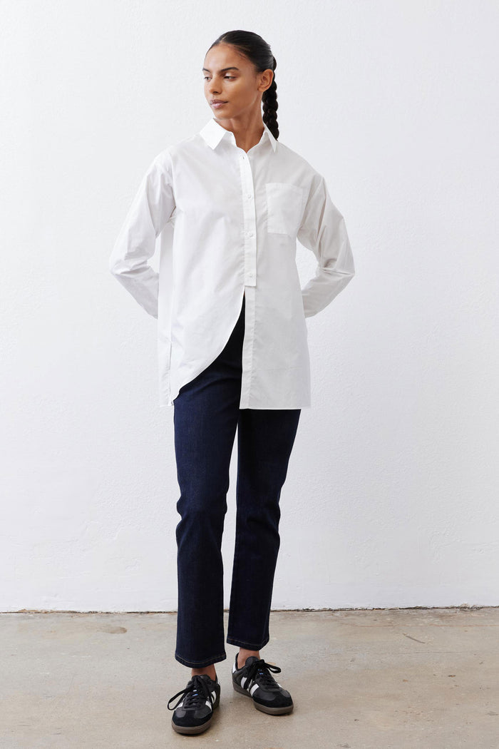 White asymmetric button-down shirt with pointed collar and long sleeves, front split