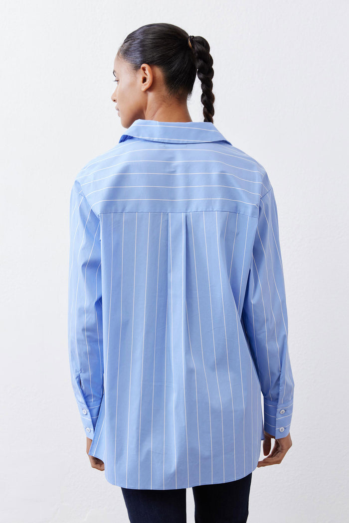 Back view of light blue striped button-down shirt with yoke and button cuffs