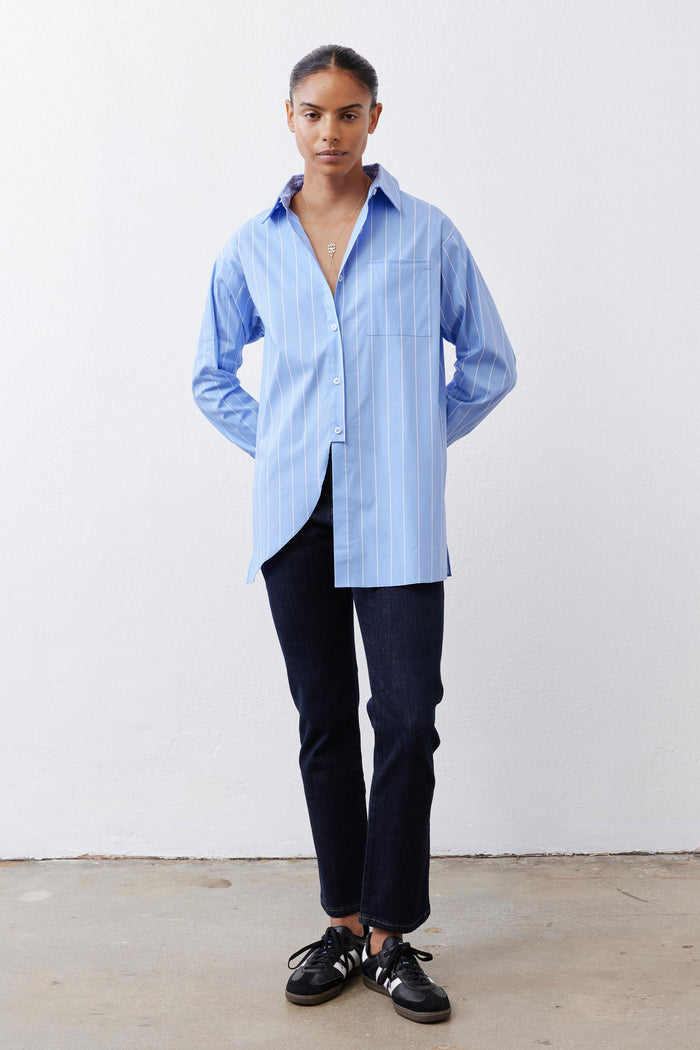 Light blue striped button-down shirt with asymmetric pulled hem