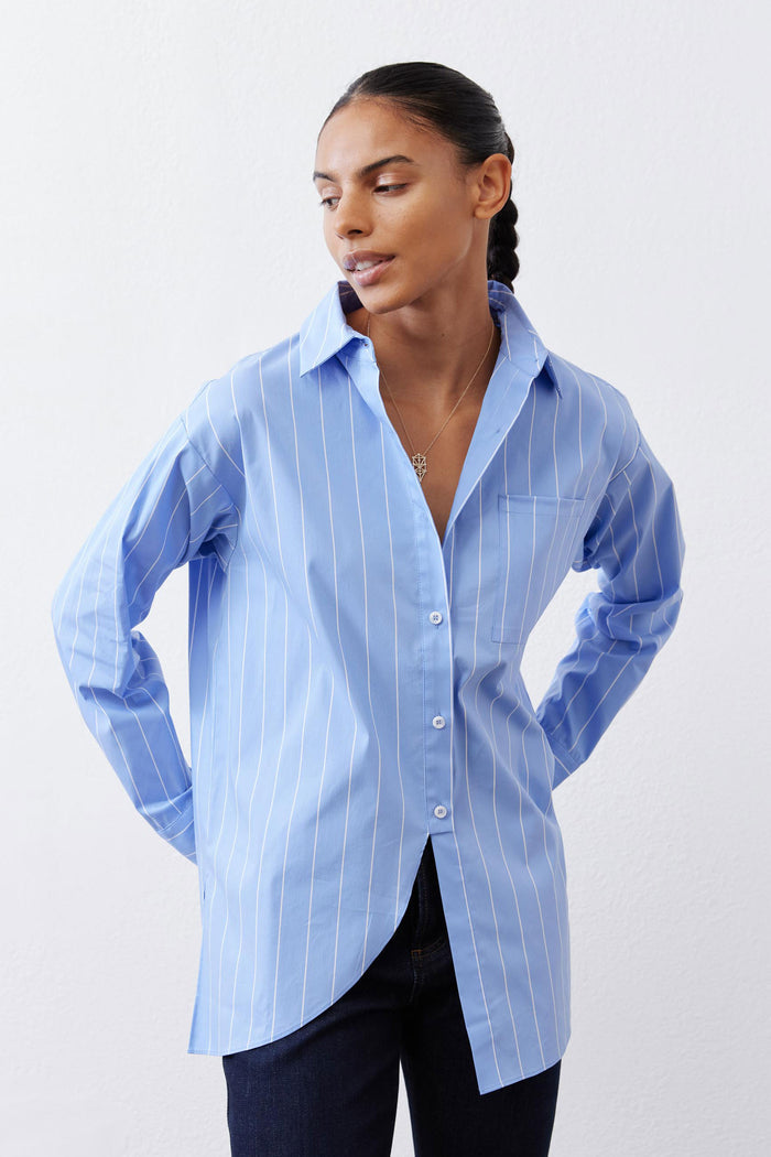 Light blue and white striped button-down shirt with front buttons and asymmetric cut