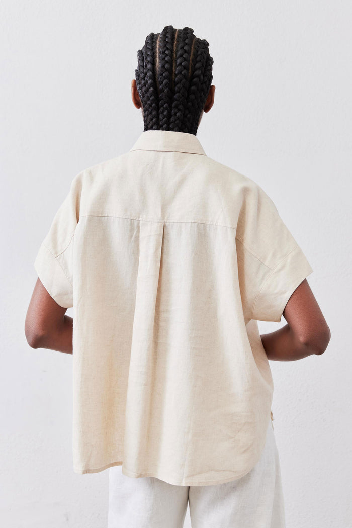 Back view of oat linen short-sleeve blouse with shoulder yoke and central seam