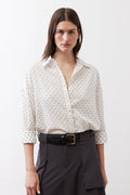 White dot-print oversized tunic with collared neckline and button front, three-quarter sleeves