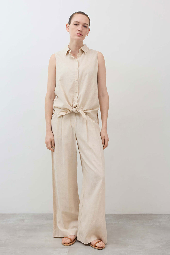 Oatmeal sleeveless button-down top with front tie knot and wide-leg trousers
