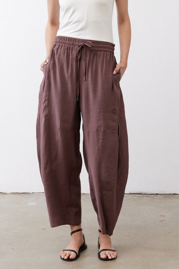 Dark brown baggy utility pants with elastic waist, drawstring, and wide tapered leg