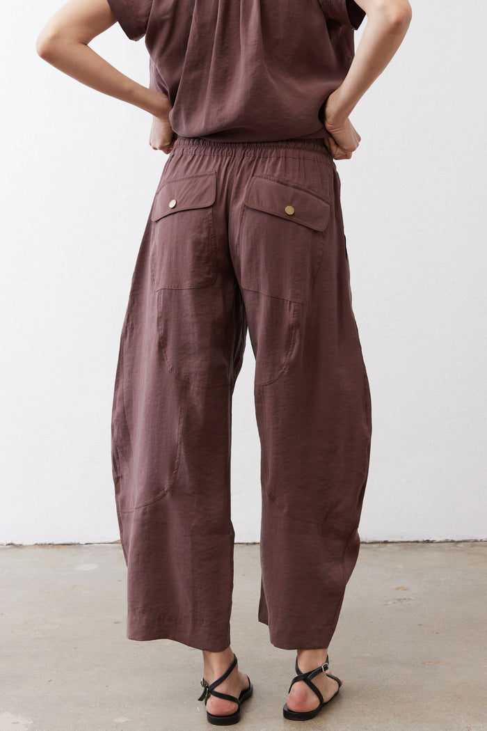 Dark brown utility pants featuring front patch pockets and elastic waistband
