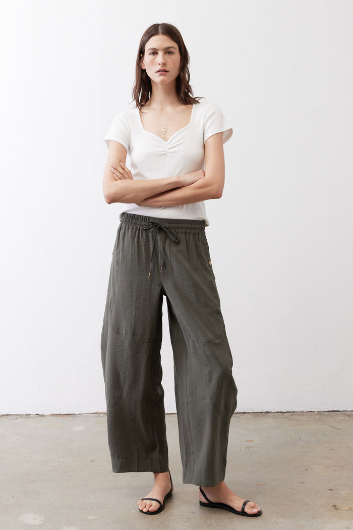 Baggy utility pants in dark olive with elastic waist, drawstring, and roomy straight legs.