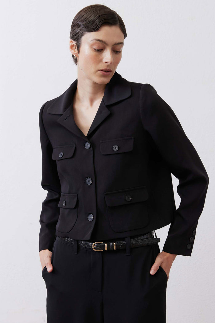 Black collared classic jacket with button front and flap chest pockets, long sleeves