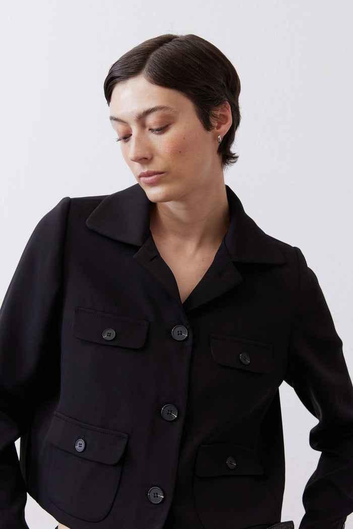 Black collared classic jacket close-up with chest flap pockets and button placket
