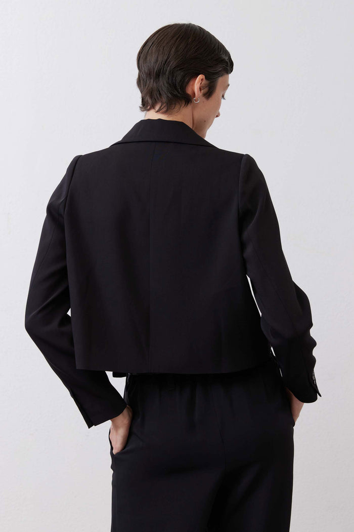 Black collared classic jacket back view with long sleeves and buttoned seams