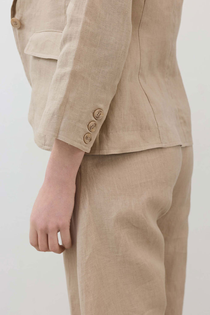 Light beige blazer sleeve detail with buttoned cuff and stitched flap pocket