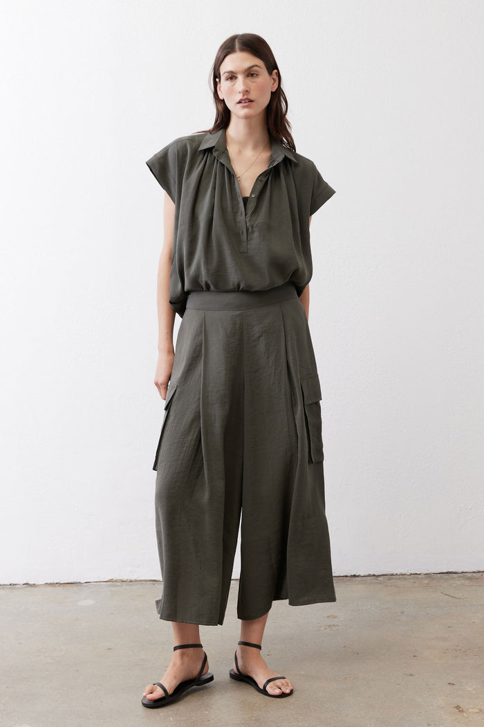Dark green cargo skirt pants with elastic waist, patch pockets, and wide legs