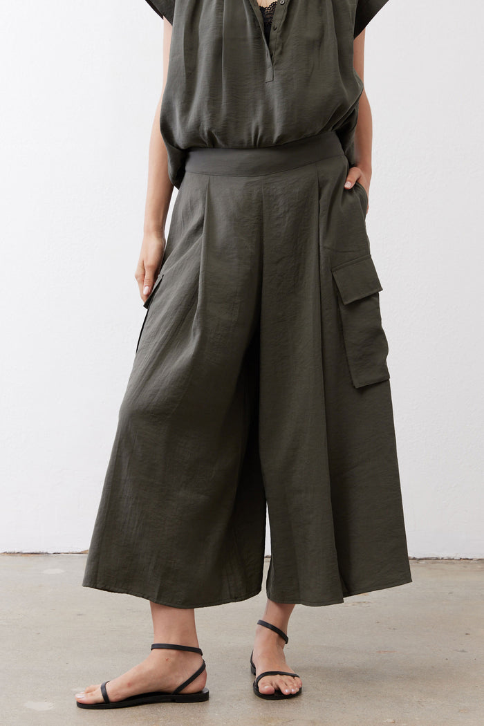 Dark green wide-leg cargo skirt pants with side flap pocket detail