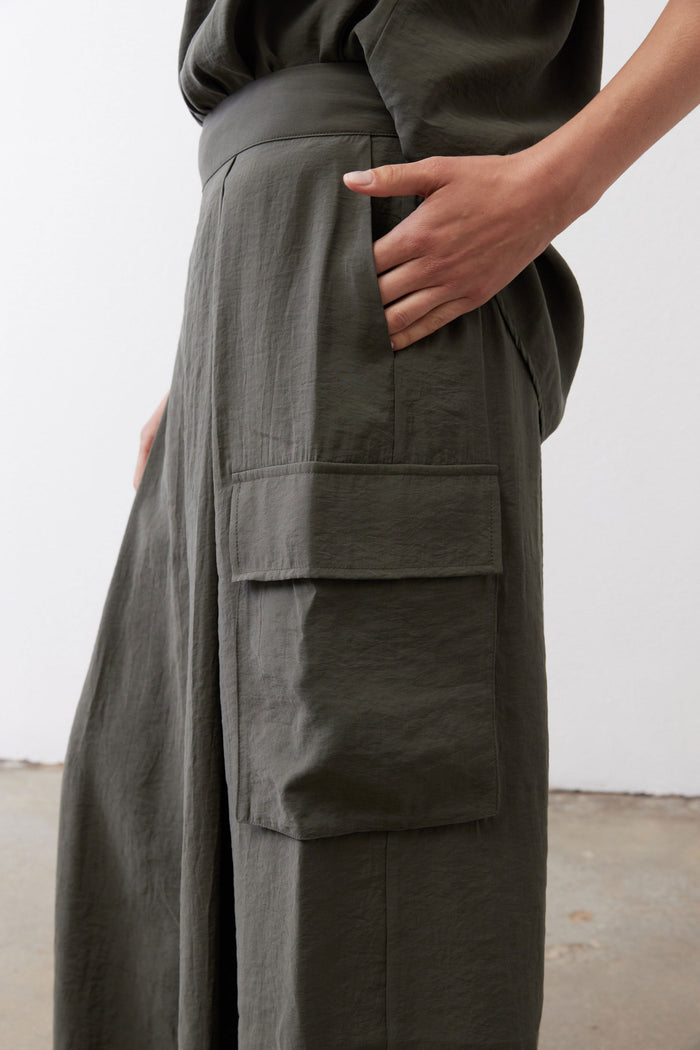 Dark green cargo skirt pants with stacked flap pockets at the side