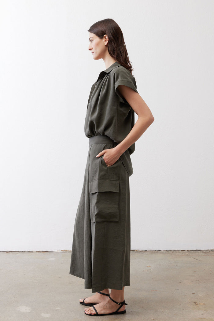 Dark green cargo skirt pants with elastic waist and side flap pockets