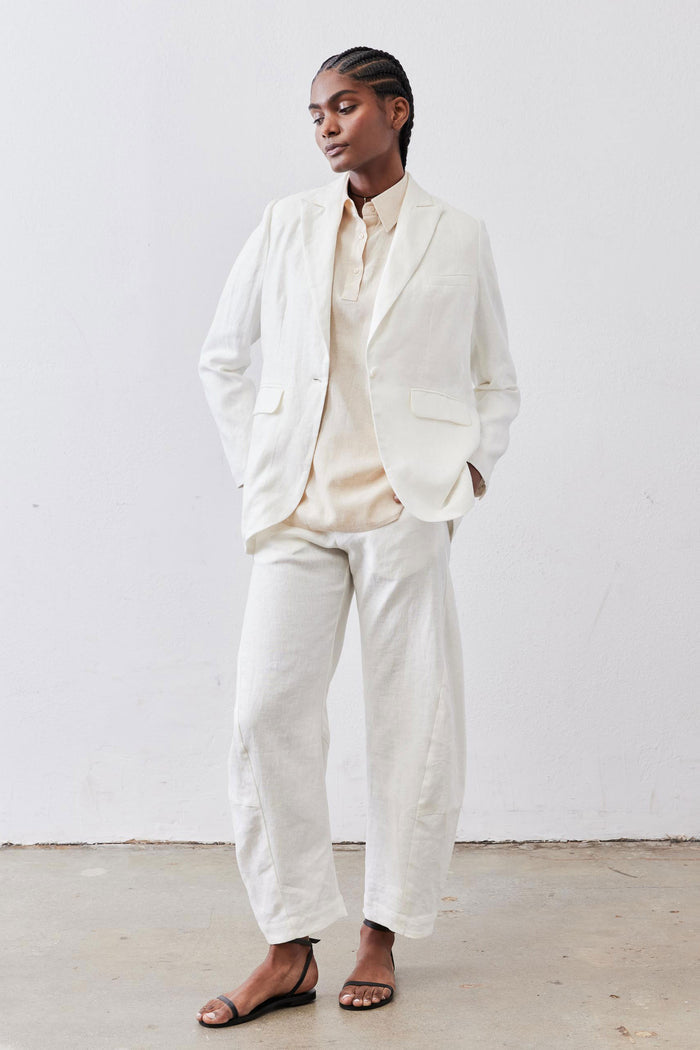 Vintage white linen blazer and matching trousers, worn by model in full-body standing pose