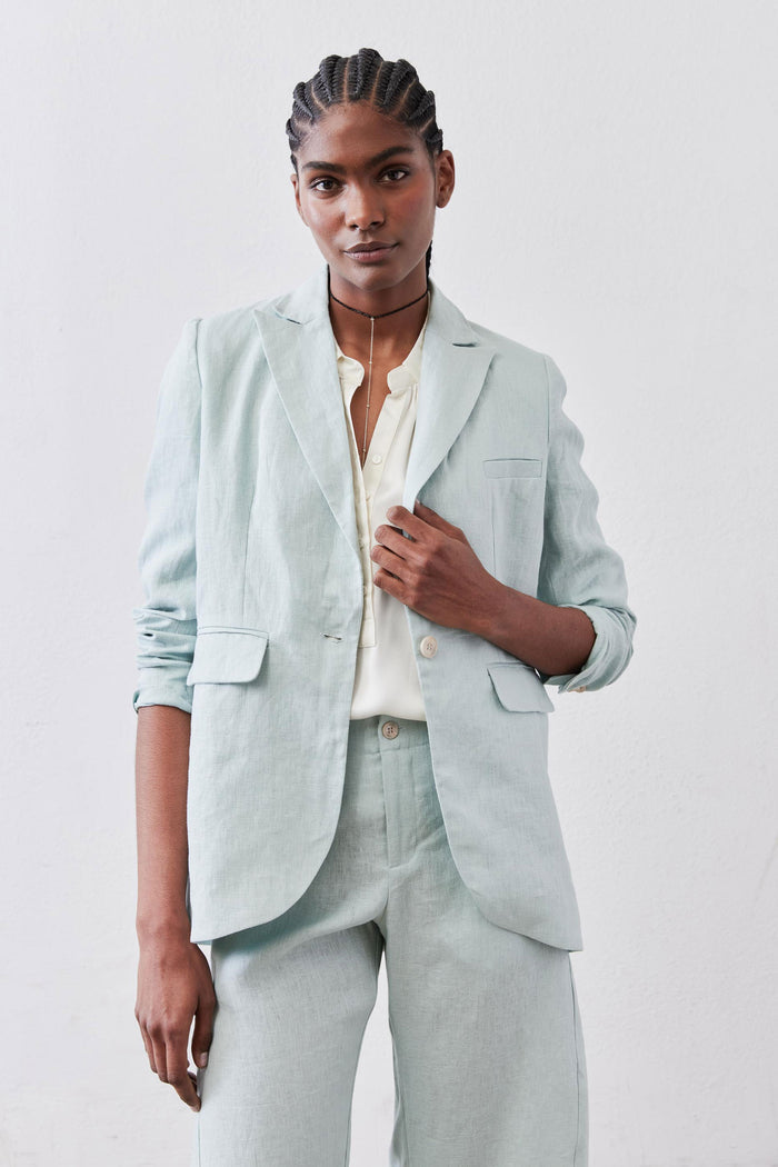 Mint linen blazer worn open, notch lapels, two flap pockets, front button closure, long sleeves