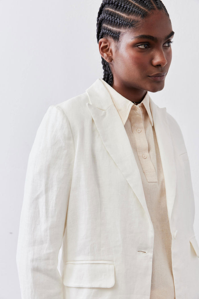 Vintage white linen blazer on model in close-up, showing shoulder and chest pocket