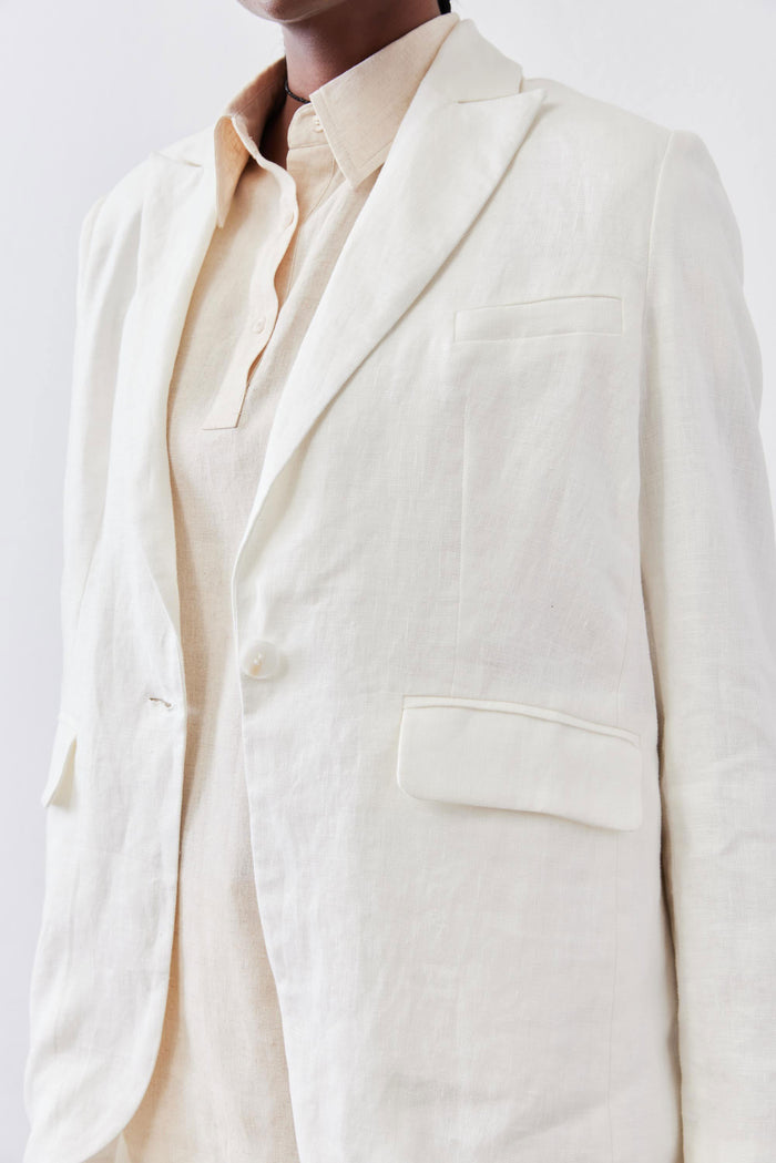 Vintage white linen blazer lapel and chest pocket detail over a light button-up