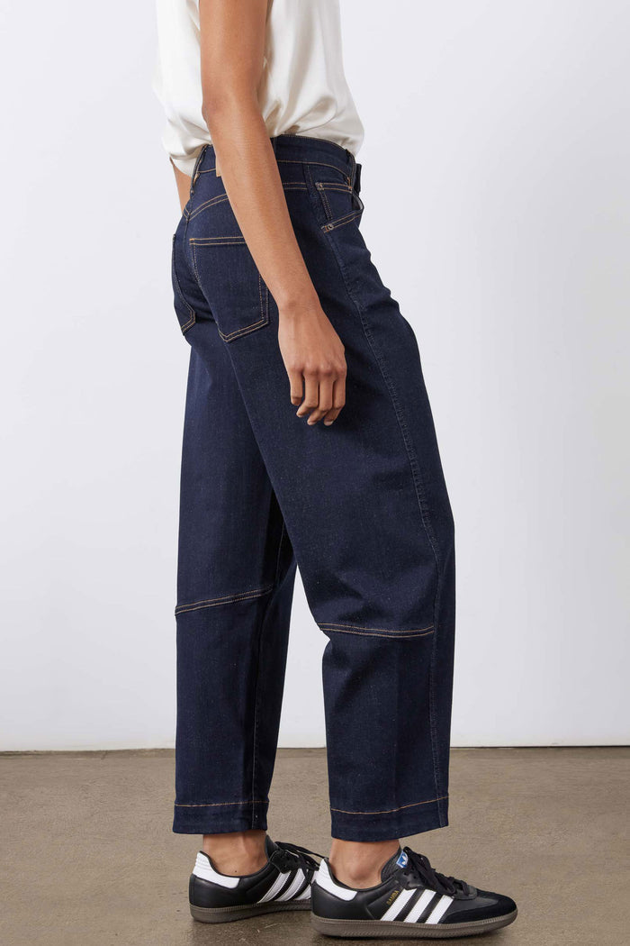 Dark wash barrel-leg jeans with side panel seams and cuffed wide hem