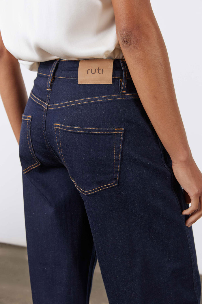 Dark wash barrel-leg jeans with leather waistband brand label and belt loops
