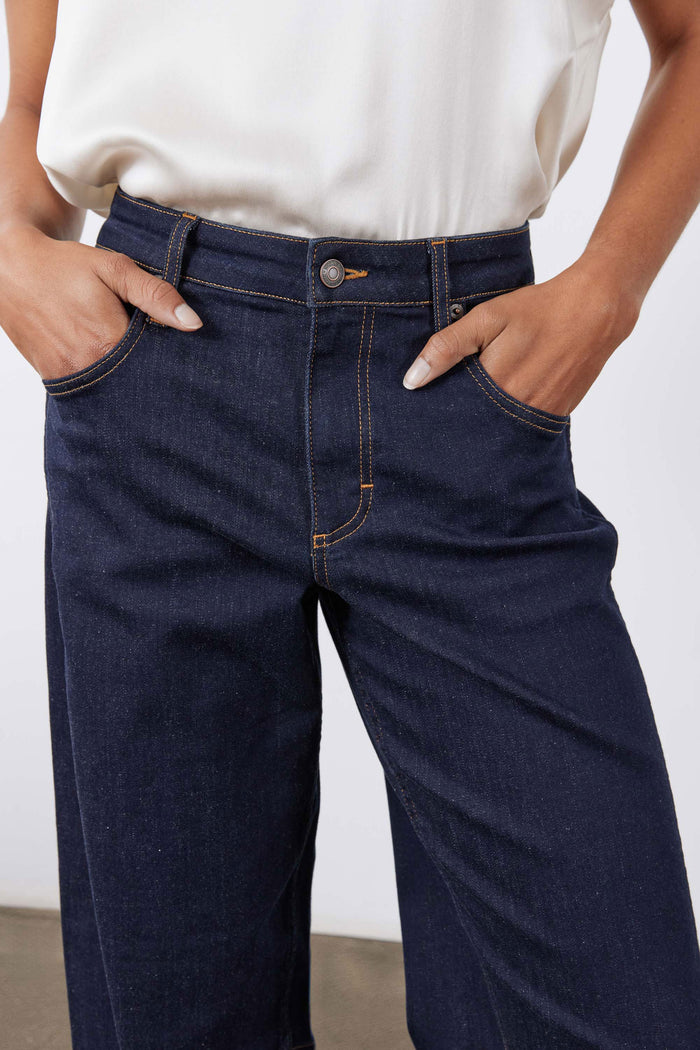 Dark wash barrel-leg jeans with zip fly and front patch pockets