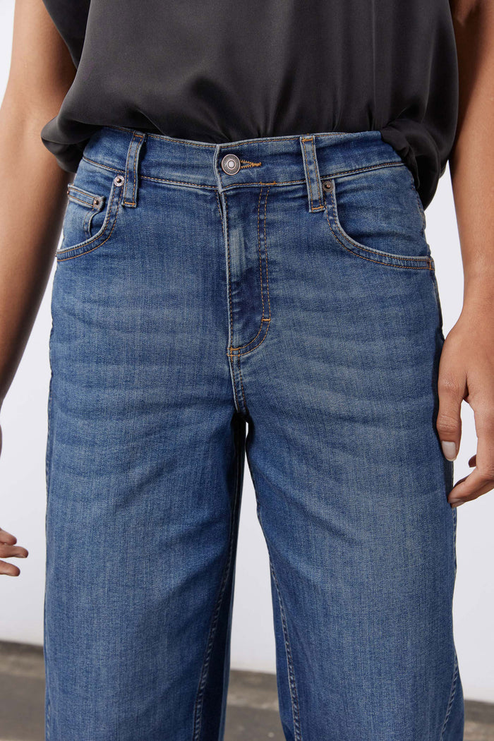 Indigo jeans with button fly, front patch pockets, and curved yoke seam